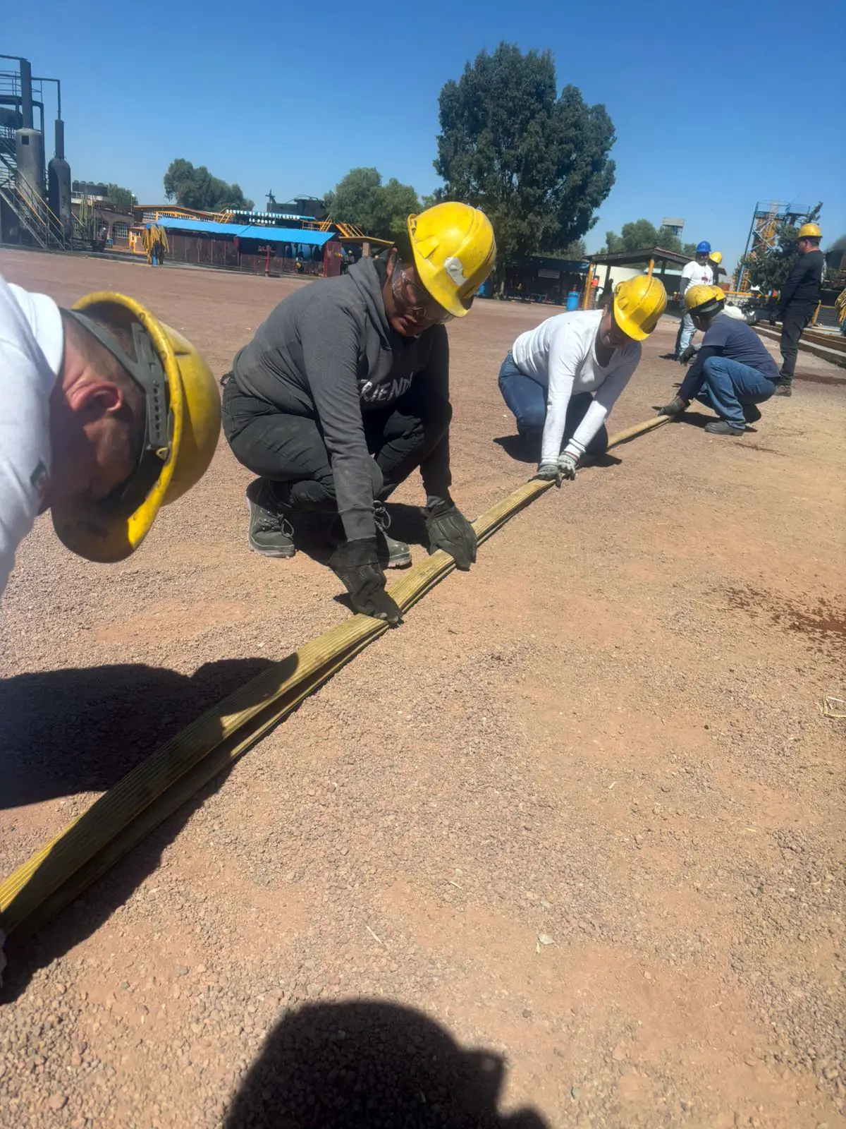 Participantes tendiendo líneas de manguera en el campo de prácticas
