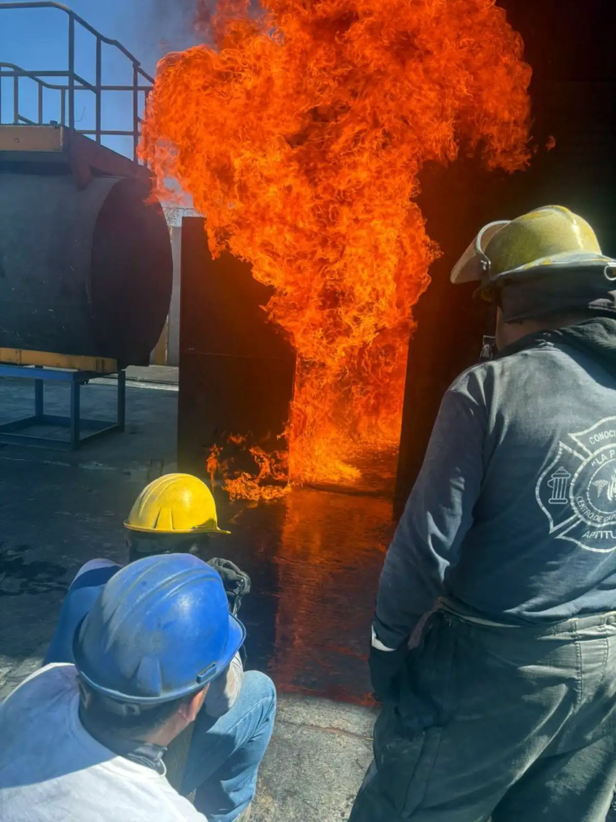 Brigadistas observando práctica con fuego real en campo de entrenamiento