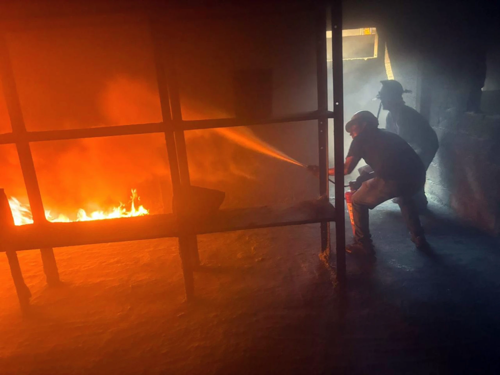 Práctica de ataque al fuego con manguera en simulador de incendios