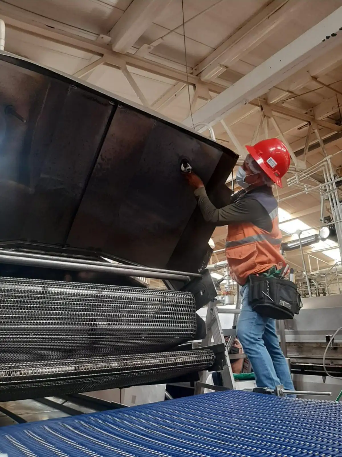Técnico de ISDEI instalando sistema de supresión en maquinaria industrial