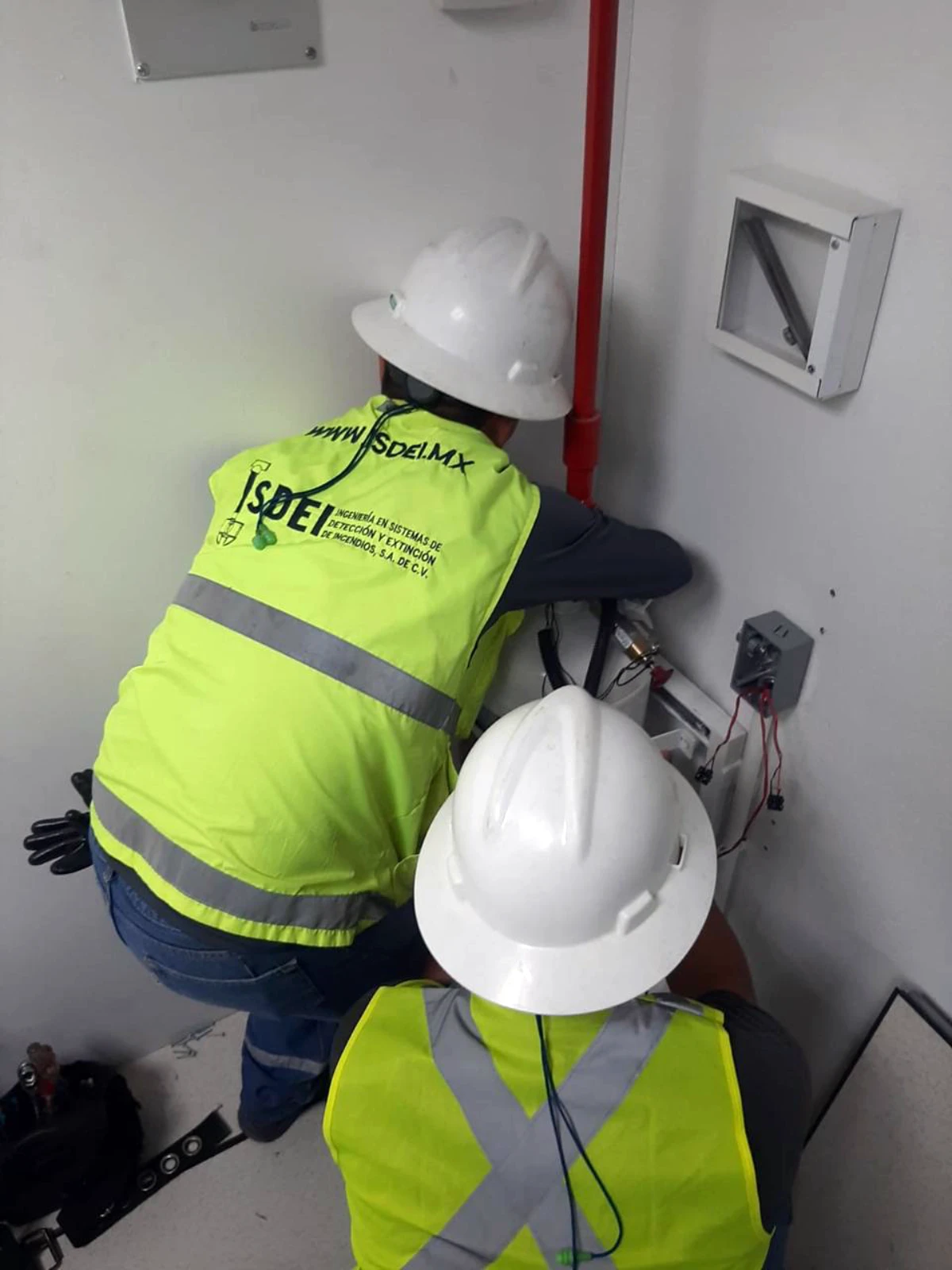 Técnicos de ISDEI conectando dispositivos de un sistema de supresión